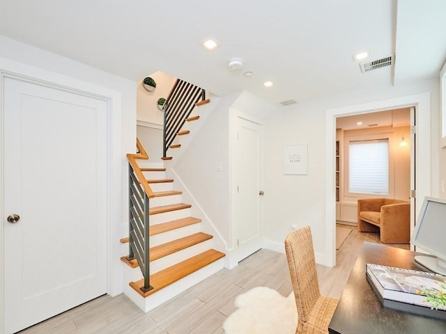 staircase with baseboards, visible vents, wood finished floors, and recessed lighting