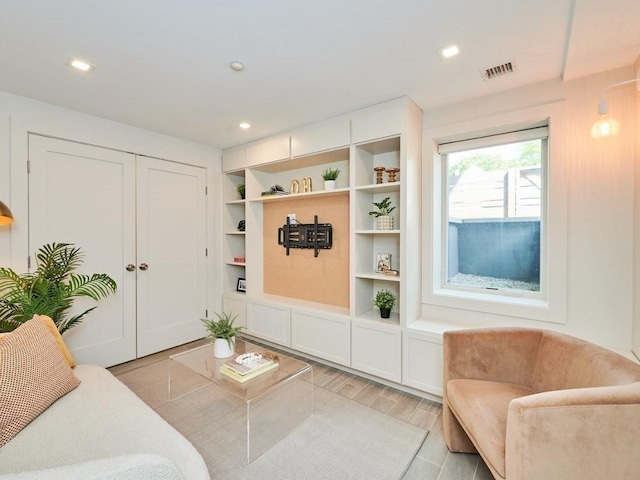 living room featuring light wood finished floors, visible vents, and recessed lighting