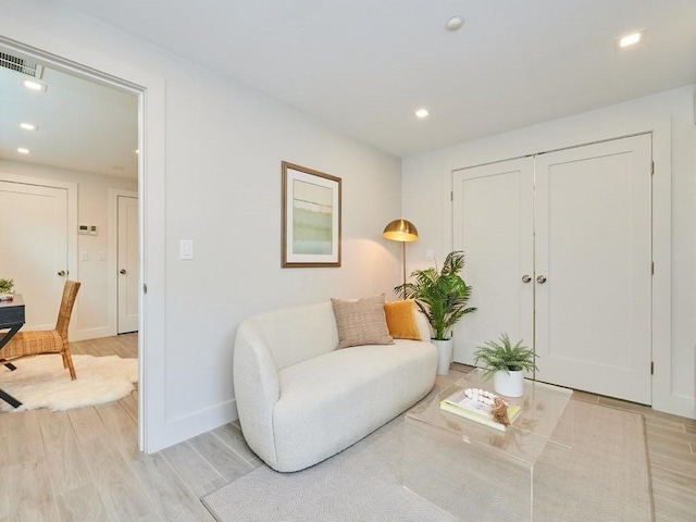 living area featuring recessed lighting, baseboards, visible vents, and light wood finished floors