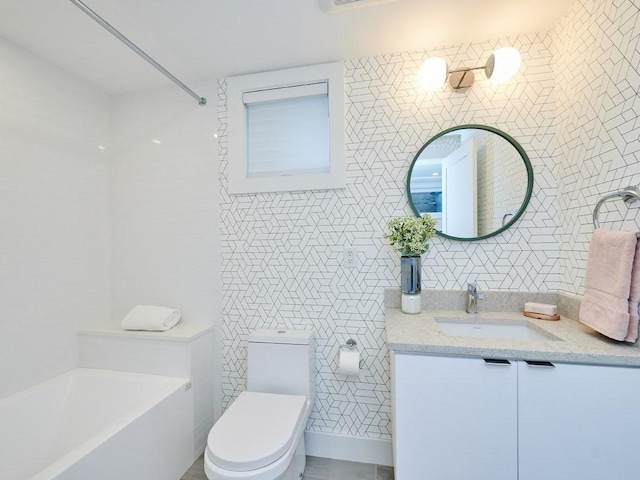 bathroom featuring vanity, toilet, and tile walls