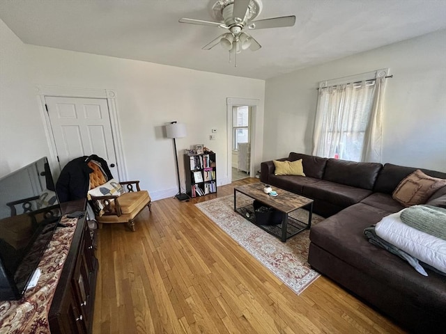 living room featuring ceiling fan, light hardwood / wood-style flooring, and a healthy amount of sunlight