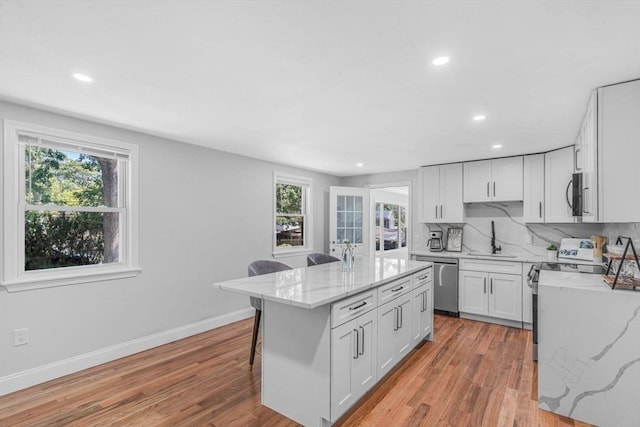 46 Curtis St, Brockton, MA 02301 - kitchen with range, stainless steel dishwasher, recessed lighting, light stone counters, and light wood finished floors