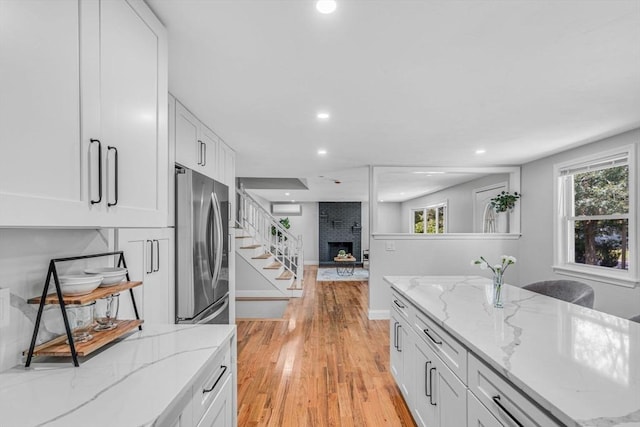 46 Curtis St, Brockton, MA 02301 - kitchen with light wood finished floors, white cabinetry, recessed lighting, a fireplace, and freestanding refrigerator