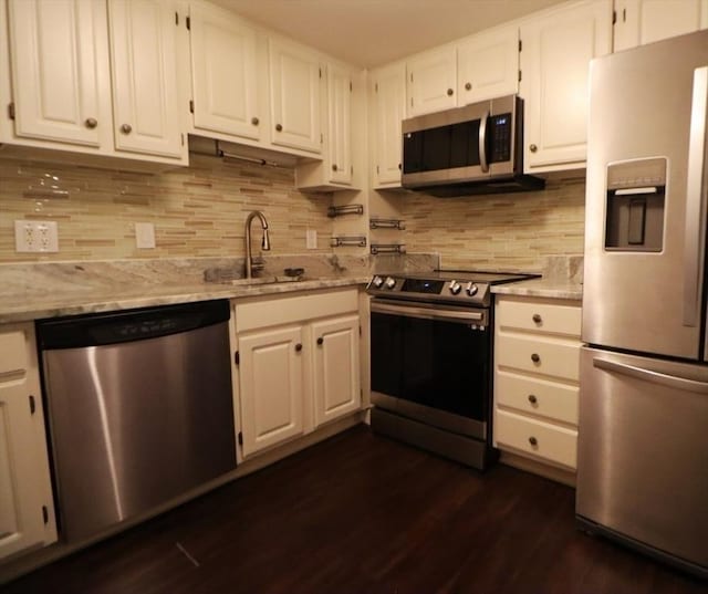 kitchen featuring decorative backsplash, stainless steel appliances, sink, white cabinets, and dark hardwood / wood-style floors