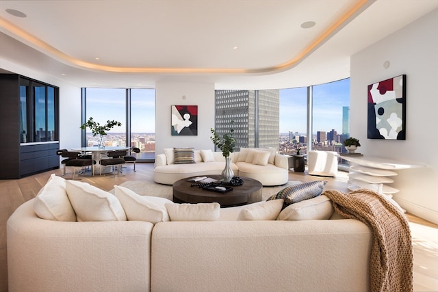 living room featuring a wall of windows, light hardwood / wood-style flooring, and a wealth of natural light