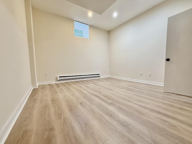 empty room featuring light wood-style floors, recessed lighting, baseboards, and baseboard heating