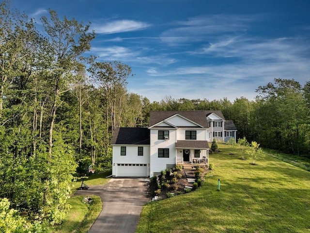 182 Sheldon Rd, Fitchburg, MA 01420 - traditional-style house with asphalt driveway, covered porch, an attached garage, a front lawn, and a forest view