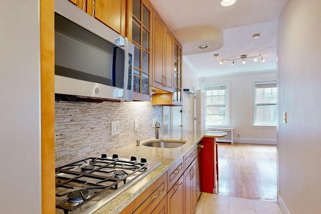 11 Irving St Unit 4, Boston, MA 02114 - kitchen with stainless steel appliances, crown molding, a sink, light stone countertops, and decorative backsplash