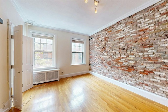11 Irving St Unit 4, Boston, MA 02114 - empty room with radiator, crown molding, wood finished floors, brick wall, and baseboards