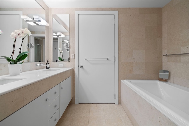 bathroom featuring vanity, tile patterned floors, and a relaxing tiled tub