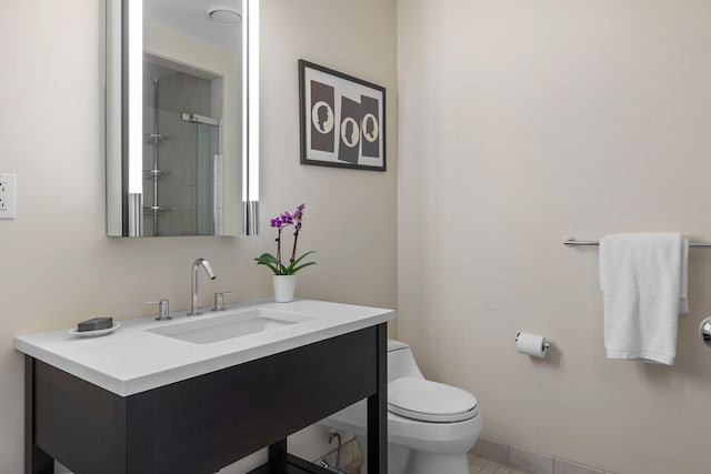 bathroom with a shower with shower door, tile patterned flooring, toilet, and vanity