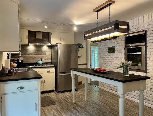947 Burts Pit Rd, Northampton, MA 01062 - kitchen featuring stainless steel appliances, wall chimney range hood, dark countertops, and light wood-style flooring