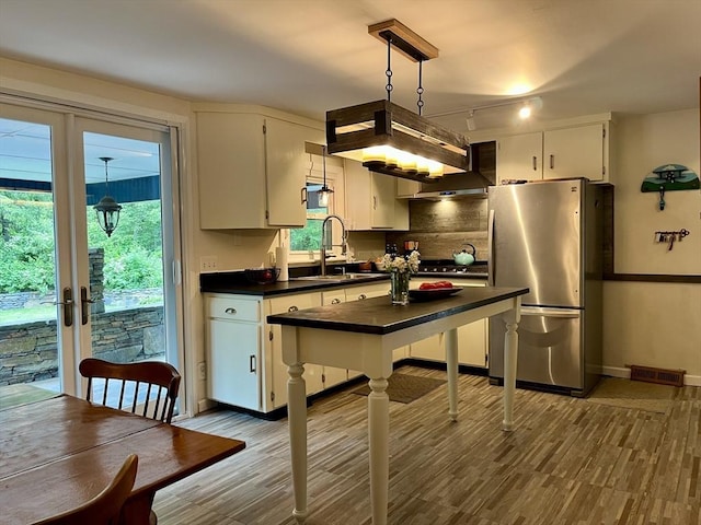 947 Burts Pit Rd, Northampton, MA 01062 - kitchen with appliances with stainless steel finishes, dark countertops, wood finished floors, white cabinetry, and rail lighting
