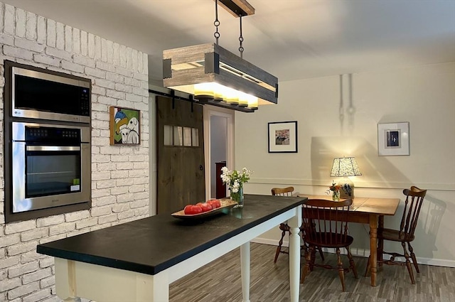 947 Burts Pit Rd, Northampton, MA 01062 - kitchen with stainless steel appliances, wood finished floors, a barn door, and dark countertops