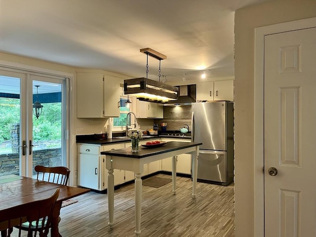 947 Burts Pit Rd, Northampton, MA 01062 - kitchen with stainless steel appliances, dark countertops, rail lighting, wall chimney exhaust hood, and white cabinetry