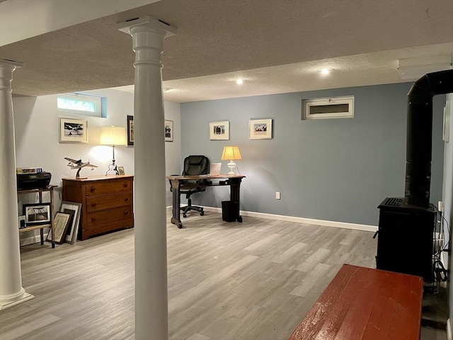 947 Burts Pit Rd, Northampton, MA 01062 - office area featuring light wood-style floors, decorative columns, a textured ceiling, and a wood stove