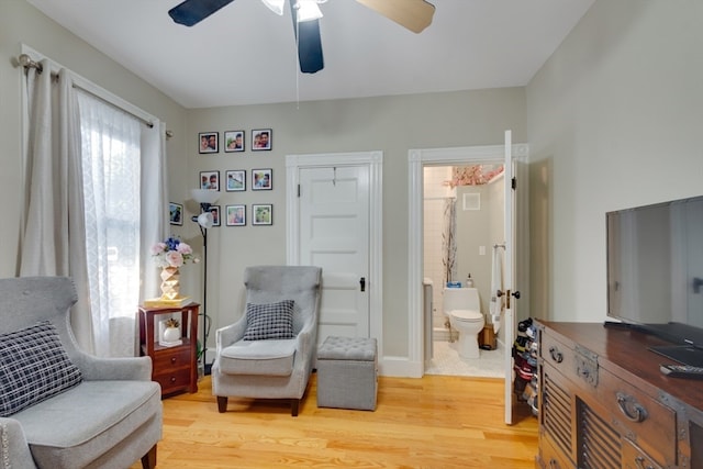 sitting room with ceiling fan and hardwood / wood-style floors