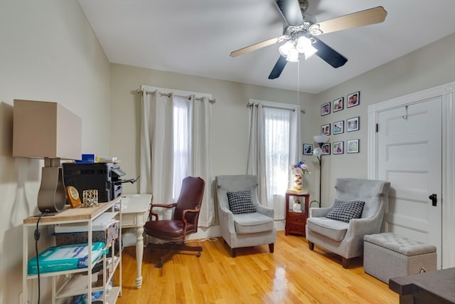 living area with light hardwood / wood-style flooring and ceiling fan