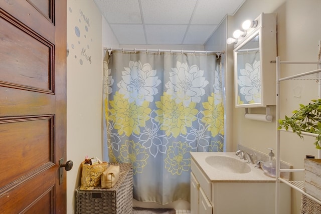 bathroom featuring vanity and a drop ceiling