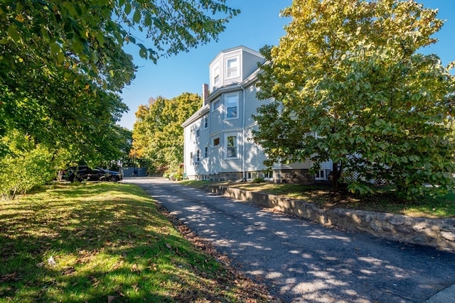 view of property exterior featuring a lawn