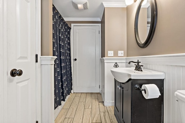 bathroom featuring crown molding, vanity, toilet, and hardwood / wood-style flooring