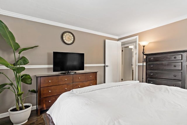 bedroom with ornamental molding and dark hardwood / wood-style flooring