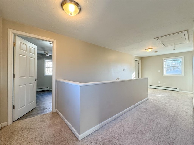 corridor featuring a baseboard heating unit and light carpet