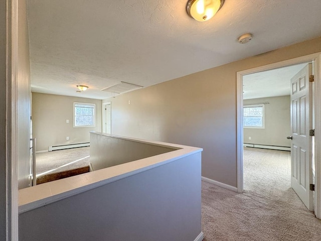 hall featuring a baseboard radiator, carpet floors, and a textured ceiling