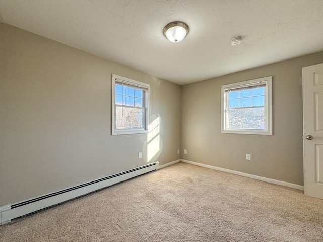 empty room featuring light carpet and baseboard heating