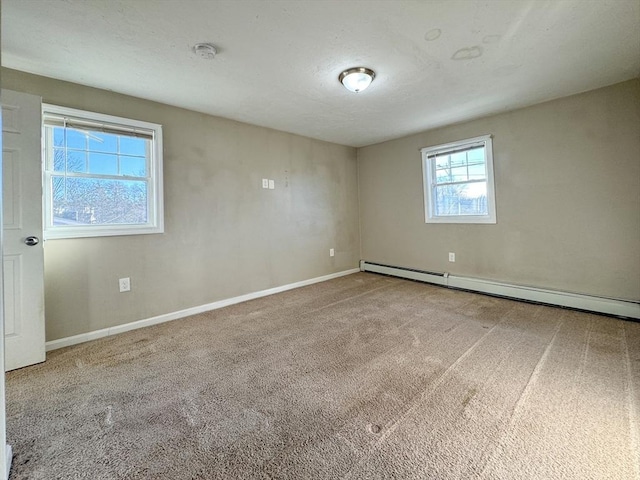 spare room with a baseboard heating unit and carpet