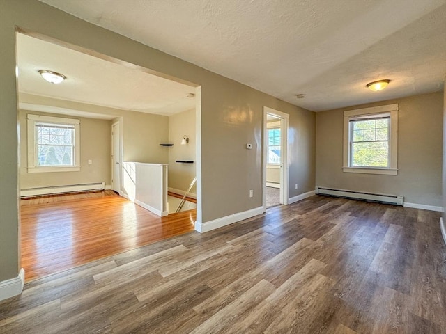 spare room featuring hardwood / wood-style flooring, a baseboard radiator, and a textured ceiling