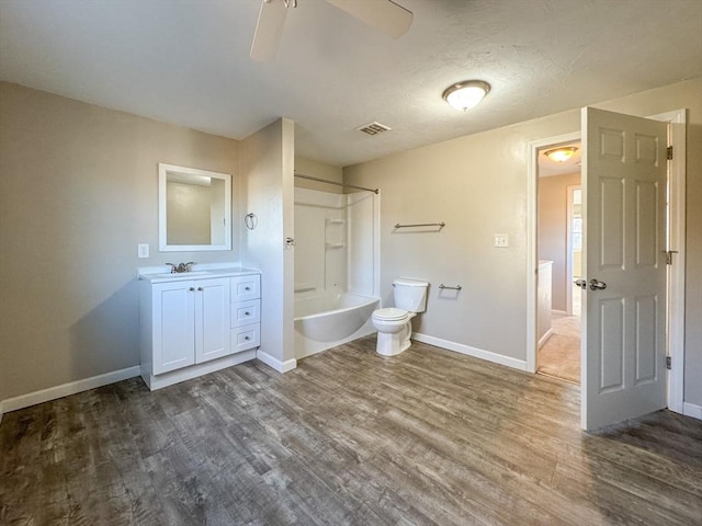 full bathroom with ceiling fan, vanity, wood-type flooring, bathtub / shower combination, and toilet