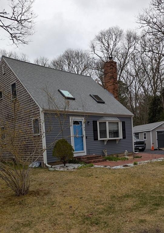 92 Santuit Pond Rd, Mashpee, MA 02649 - view of front of house with a chimney, a shingled roof, and a front lawn