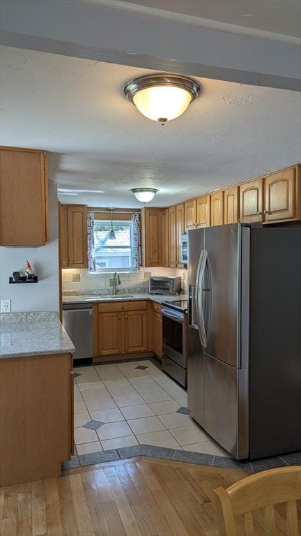92 Santuit Pond Rd, Mashpee, MA 02649 - kitchen with appliances with stainless steel finishes, light wood-style flooring, a sink, and light stone counters