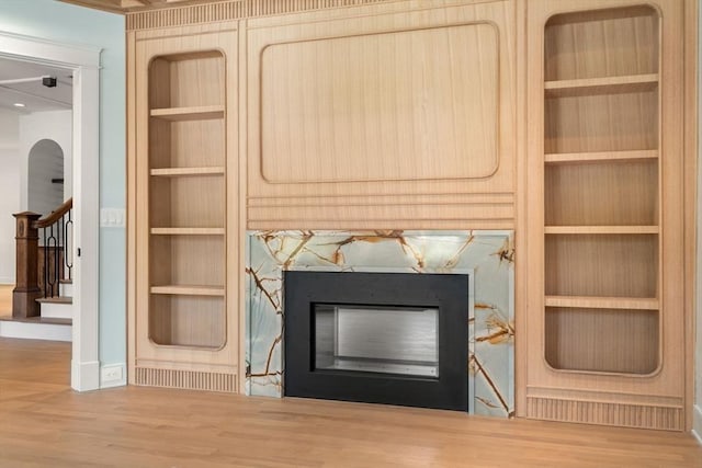 61 Westbourne Rd, Newton, MA 02459 - detailed view of built in shelves, a glass covered fireplace, baseboards, and wood finished floors