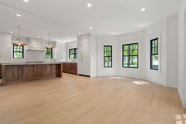 61 Westbourne Rd, Newton, MA 02459 - unfurnished living room featuring light wood-style flooring, recessed lighting, baseboards, and a sink