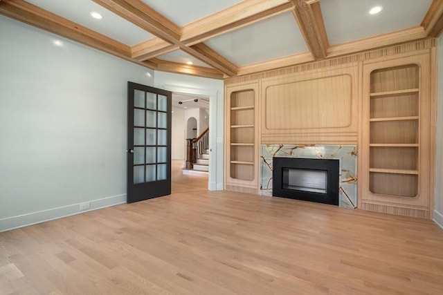 61 Westbourne Rd, Newton, MA 02459 - unfurnished living room with a fireplace, baseboards, arched walkways, wood finished floors, and beam ceiling