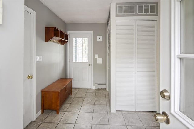 mudroom with baseboard heating, light tile patterned floors, and baseboards
