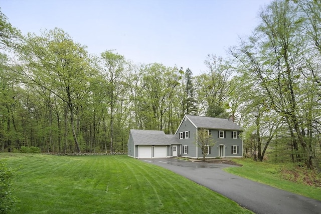colonial inspired home featuring driveway, a front lawn, and a garage