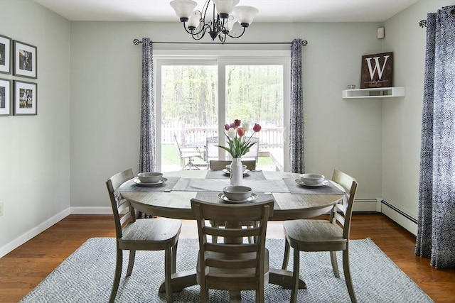 dining room with plenty of natural light, a chandelier, baseboard heating, and wood finished floors
