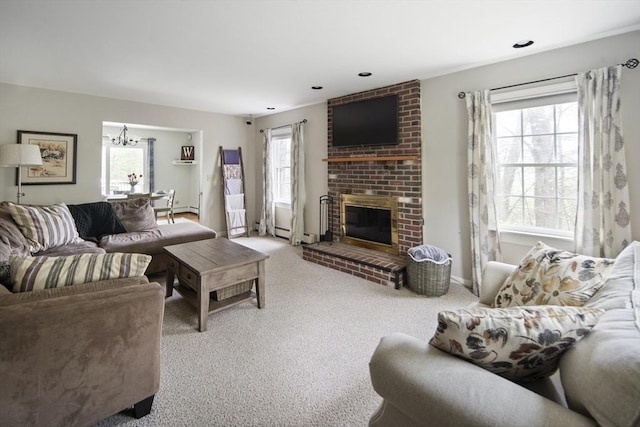 carpeted living room featuring plenty of natural light, a brick fireplace, a chandelier, and a baseboard radiator