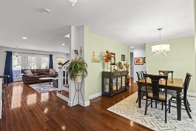 dining area featuring french doors, dark hardwood / wood-style flooring, and a notable chandelier