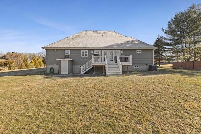 rear view of house featuring a lawn, french doors, and a wooden deck