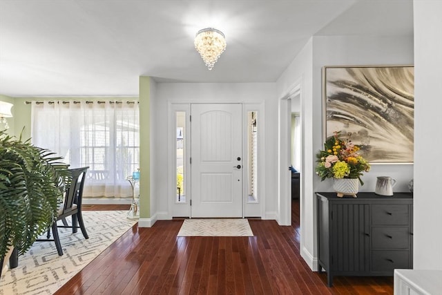 entrance foyer featuring dark hardwood / wood-style flooring and an inviting chandelier