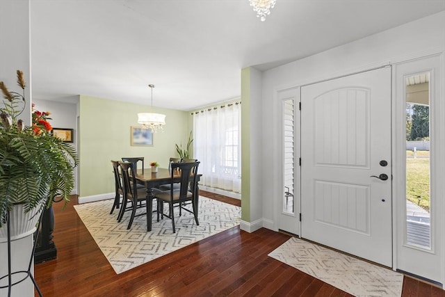 entryway featuring dark wood-type flooring and a notable chandelier