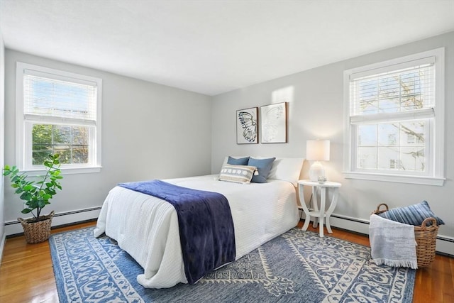 bedroom featuring a baseboard radiator and wood finished floors