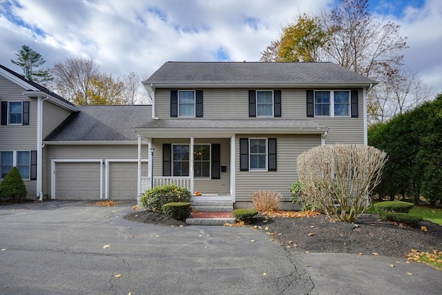 front facade featuring covered porch and a garage