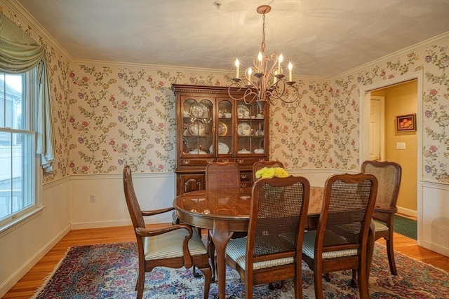 dining space featuring a chandelier, hardwood / wood-style flooring, and ornamental molding