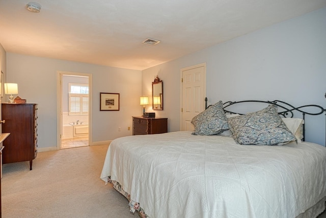 bedroom featuring light colored carpet and ensuite bathroom