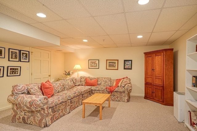 living room featuring light carpet and a drop ceiling